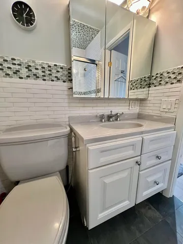 a bathroom with a toilet sink and mirror