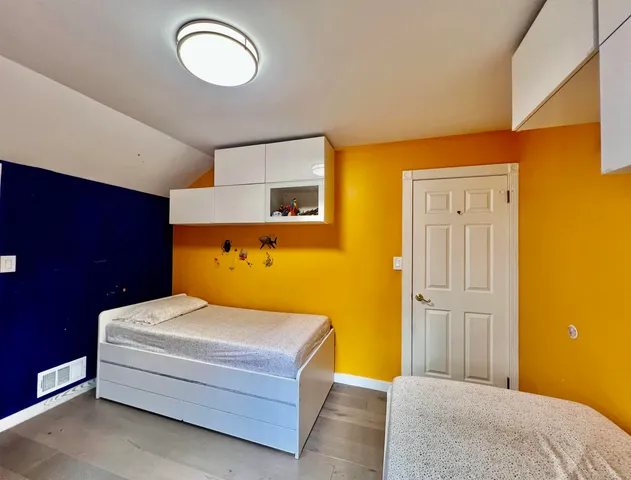 a bedroom with a bed and wooden floor