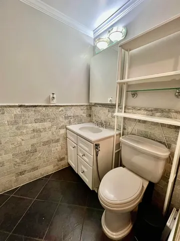 a bathroom with a granite countertop toilet sink and mirror