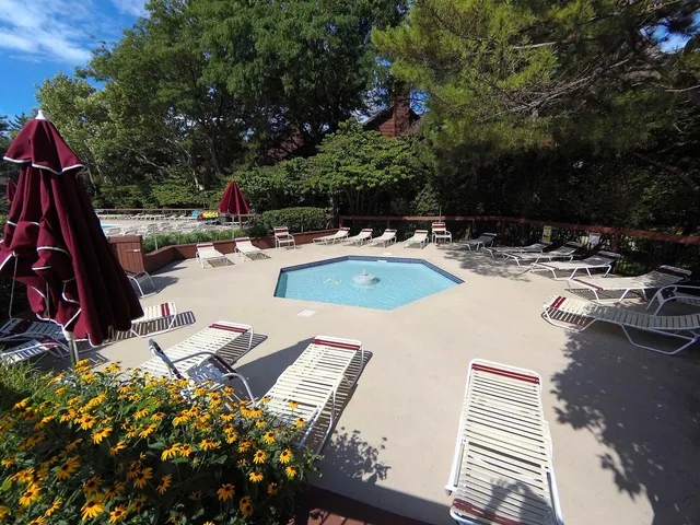 a view of backyard with swimming pool and seating space