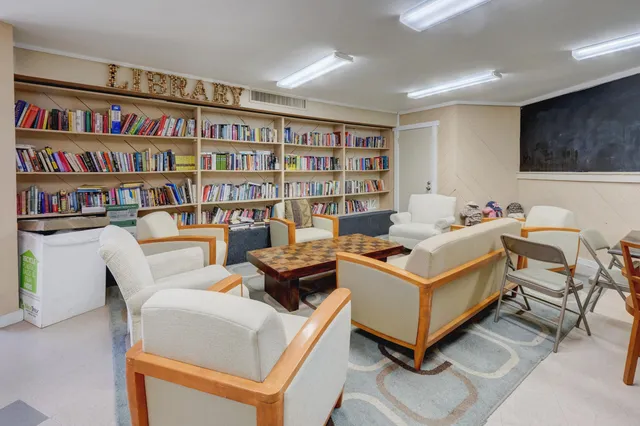 a living room with furniture and a book shelf