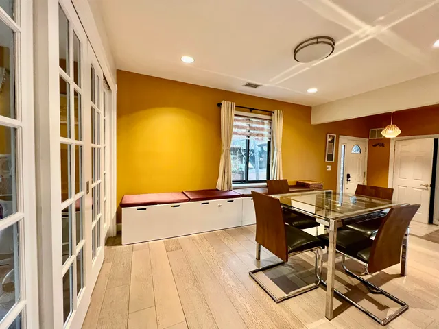 a dining room with furniture and a floor to ceiling window