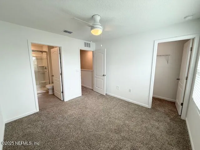 an empty room with closet and mirror