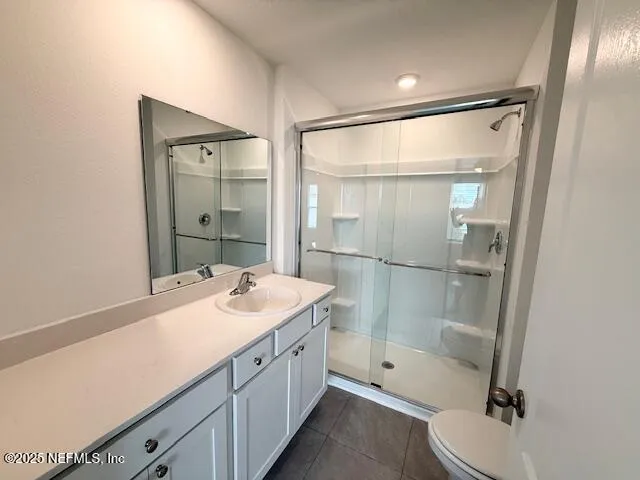 a bathroom with a sink vanity granite toilet and shower