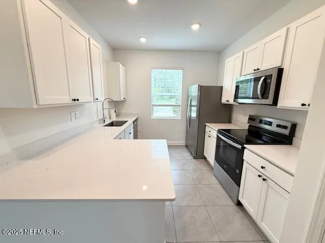 a kitchen with stainless steel appliances a refrigerator sink microwave and cabinets