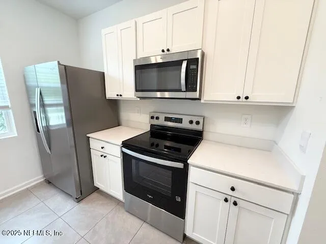 a kitchen with stainless steel appliances a stove microwave and refrigerator