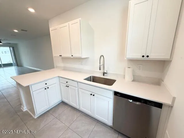 a kitchen with white cabinets appliances a sink and a window