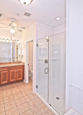 a bathroom with a granite countertop sink toilet and shower