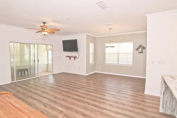 a view of an empty room with window and wooden floor