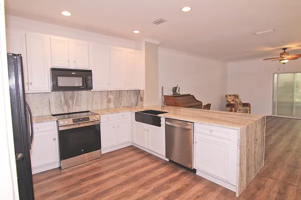 a kitchen with stainless steel appliances granite countertop a refrigerator stove and sink