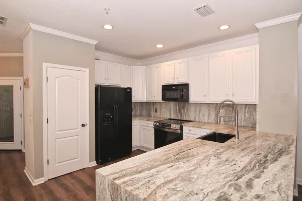 a kitchen with stainless steel appliances granite countertop a refrigerator and a sink