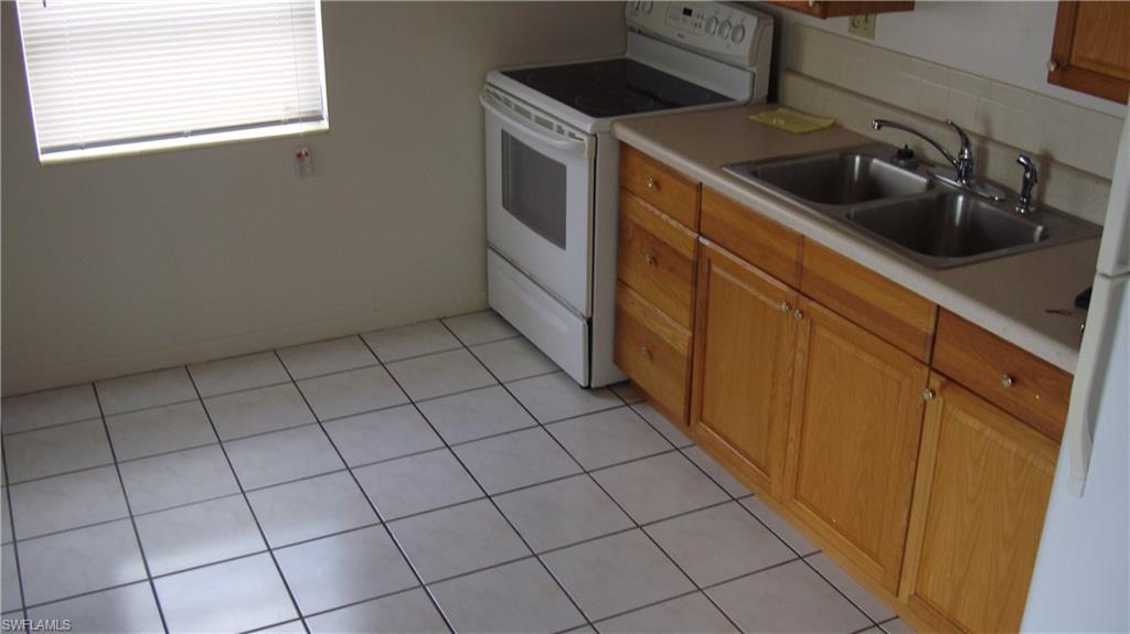 302 East Jersey Road Lehigh Acres, FL 33936 - Photo 4 of 10 a kitchen with a sink and cabinets