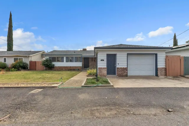a front view of house with a garden