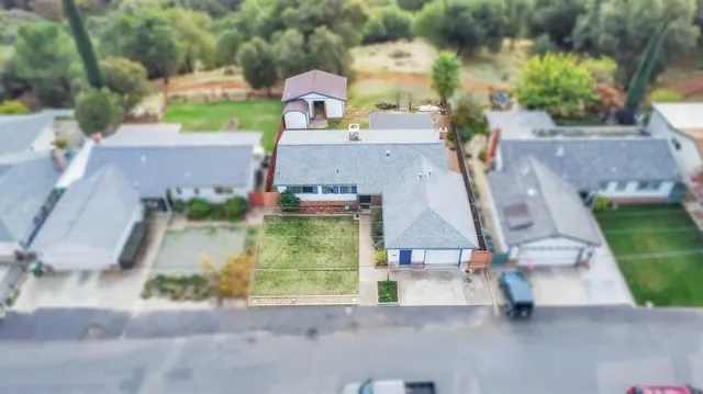 an aerial view of a house with a garden and trees