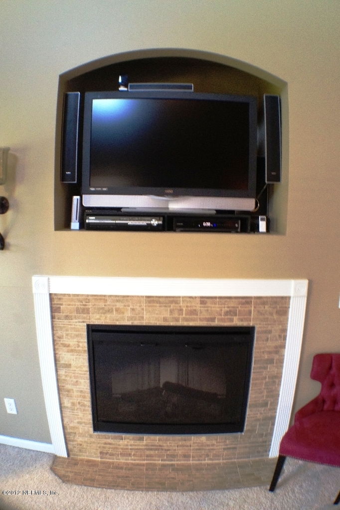 6092 White Tip Road Jacksonville, FL 32258 - Photo 13 of 32 a room with a fireplace and a flat screen tv
