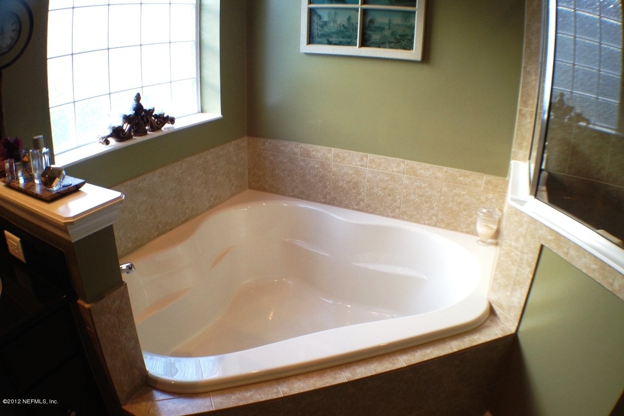 6092 White Tip Road Jacksonville, FL 32258 - Photo 18 of 32 a bath tub sitting in a bathroom next to a window