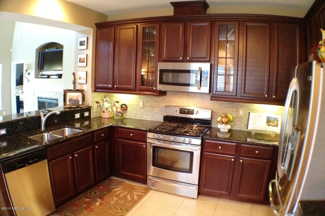 6092 White Tip Road Jacksonville, FL 32258 - Photo 2 of 32 a kitchen with granite countertop wooden cabinets stainless steel appliances and a sink