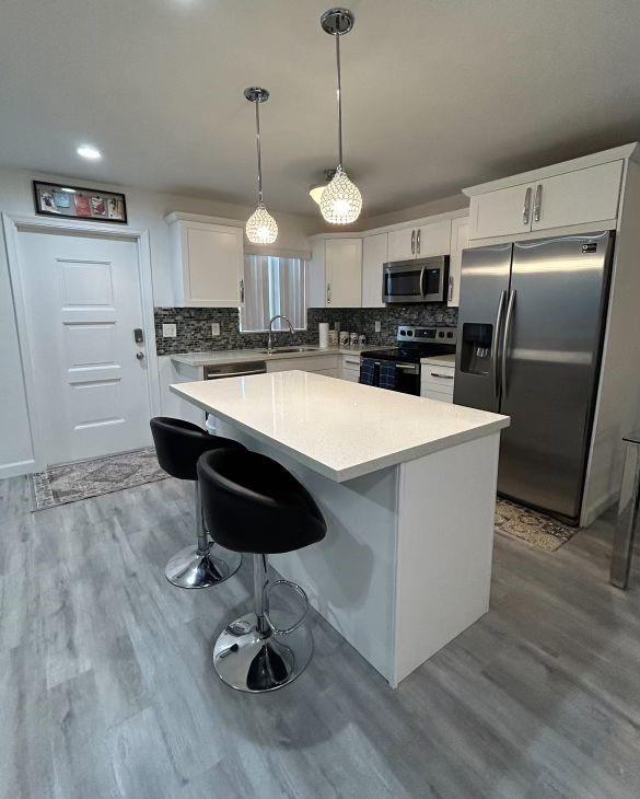 a large kitchen with kitchen island a counter space a sink appliances and cabinets