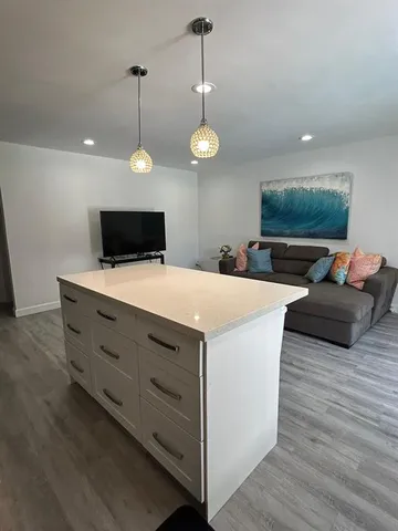 a view of a kitchen counter space a wooden floor and a fireplace