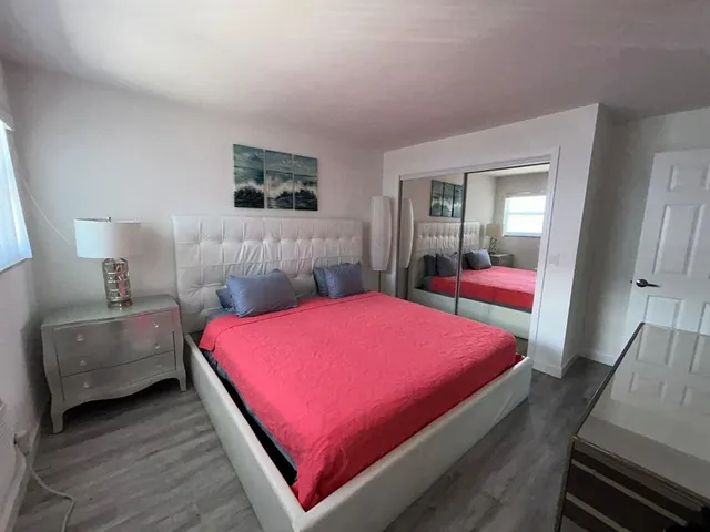 a bedroom with a bed and a potted plant