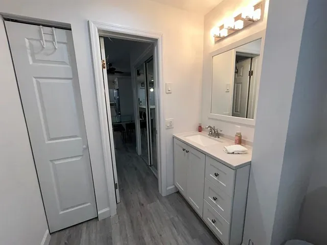 a bathroom with a sink a mirror a vanity and a toilet