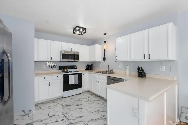 a kitchen with granite countertop a stove top oven microwave and cabinets
