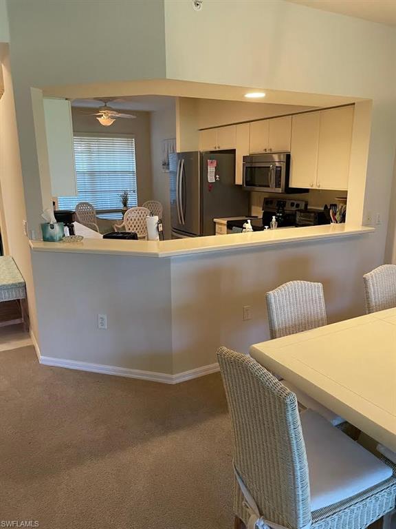 8085 Celeste Drive, Unit 812 Naples, FL 34113 - Photo 7 of 9 a living room with stainless steel appliances kitchen island granite countertop a refrigerator a sink a stove and a dining table with wooden floor