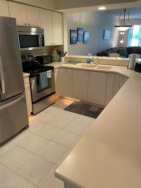 8085 Celeste Drive, Unit 812 Naples, FL 34113 - Photo 8 of 9 a kitchen with stainless steel appliances a sink a stove top oven a counter space and cabinets