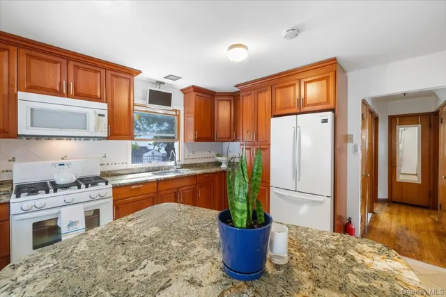 a kitchen with stainless steel appliances granite countertop a refrigerator a stove and a sink