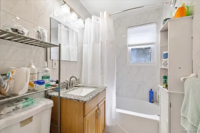 a bathroom with a sink vanity granite tub and shower