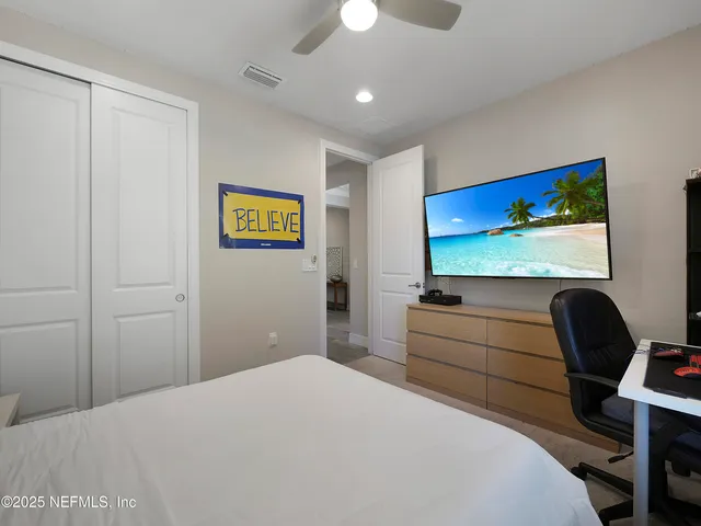 a bedroom with a bed and a flat screen tv