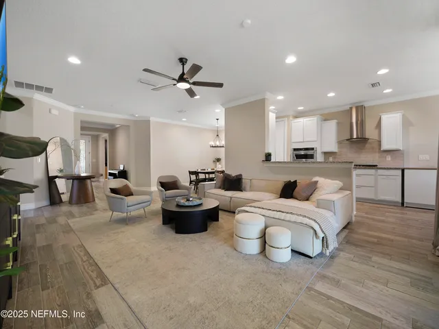 a living room with furniture and a view of kitchen