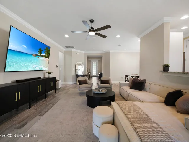 a living room with furniture a window and a flat screen tv