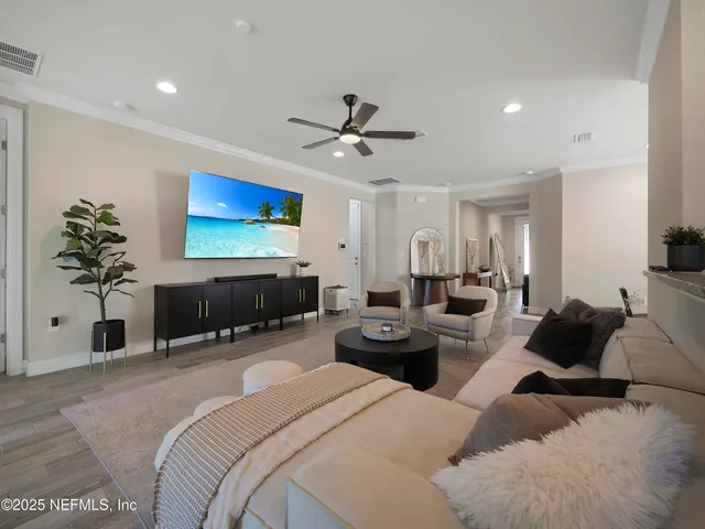 a living room with furniture a chandelier and a flat screen tv