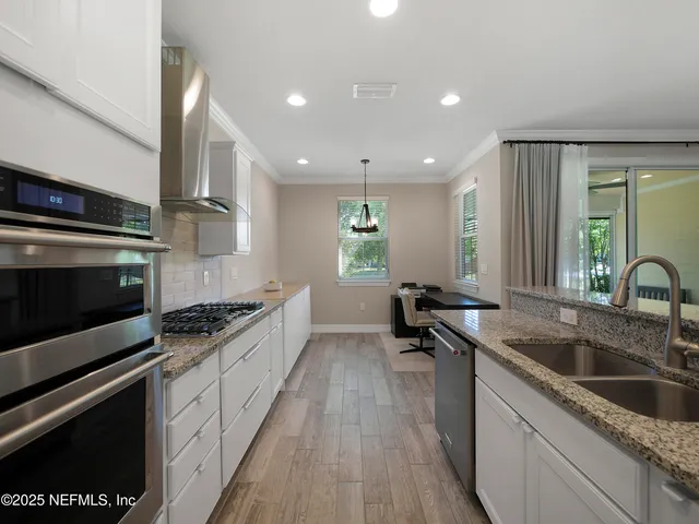 a kitchen with a sink stove top oven and cabinets