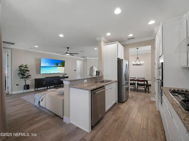 a kitchen with stainless steel appliances kitchen island granite countertop a stove and a sink