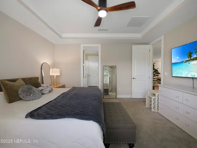 a bedroom with a bed a window and a flat screen television