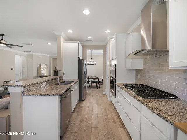 a kitchen with granite countertop a sink stove and cabinets