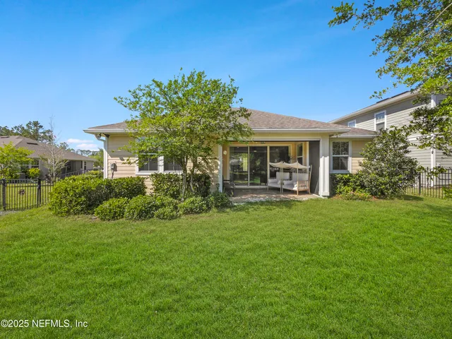 a view of a house with backyard and a tree