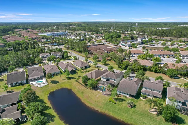 an aerial view of a city with lots of residential buildings ocean and mountain view in back