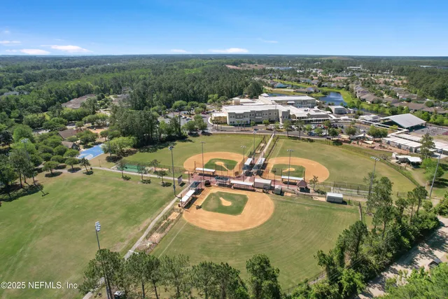 an aerial view of residential houses with outdoor space and trees