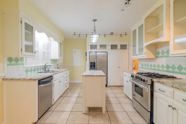 a kitchen with a sink chandelier and living room view