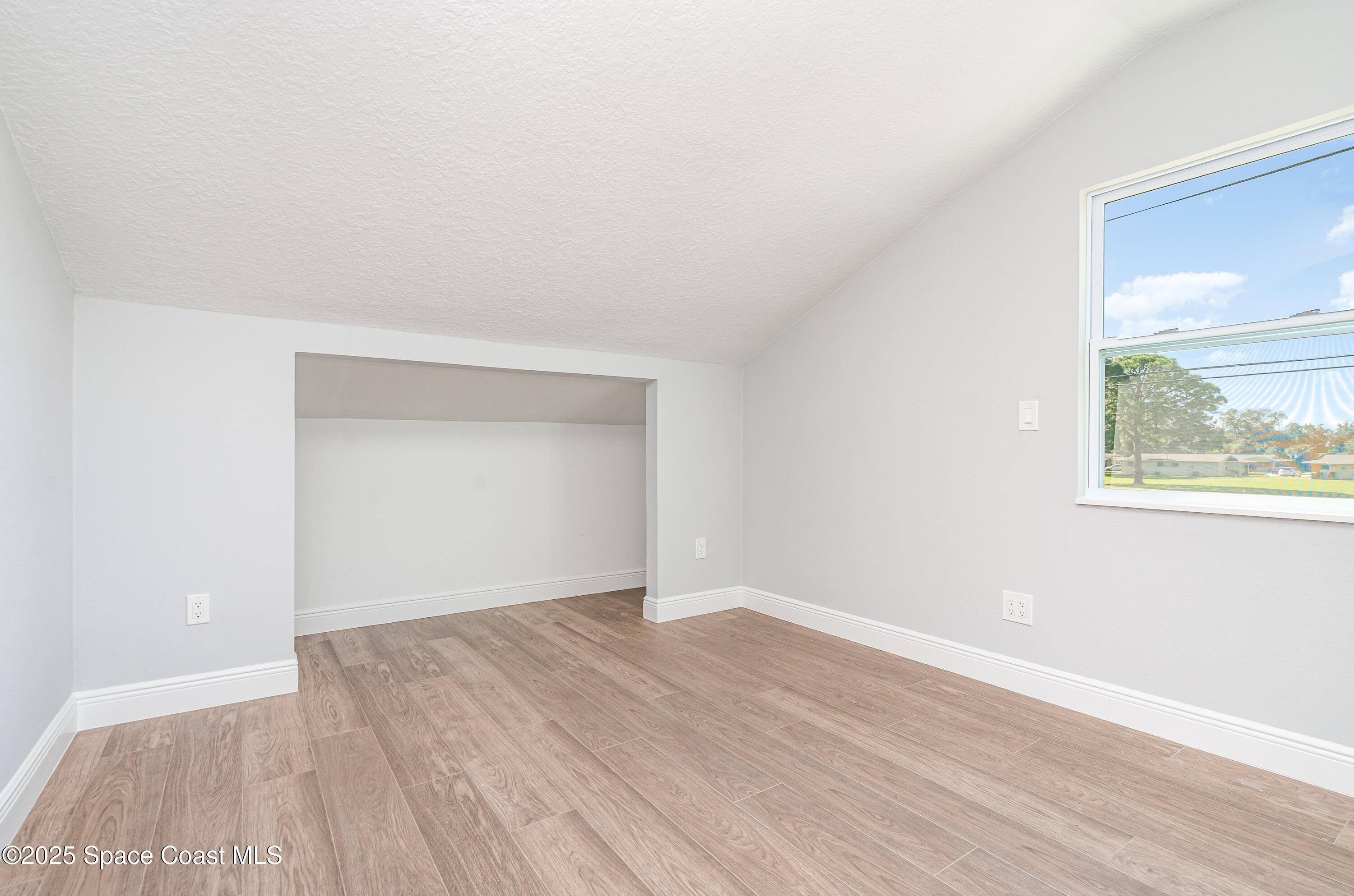 1735 Marywood Road Melbourne, FL 32934 - Photo 11 of 25 a view of an empty room with wooden floor and a window