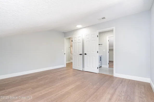 a view of empty room with wooden floor