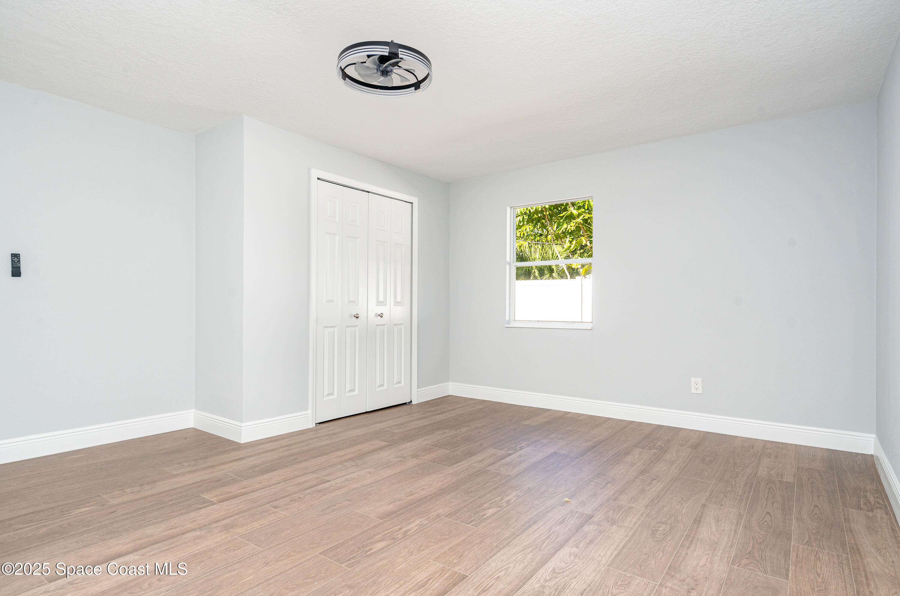 1735 Marywood Road Melbourne, FL 32934 - Photo 18 of 25 an empty room with a window and a ceiling fan