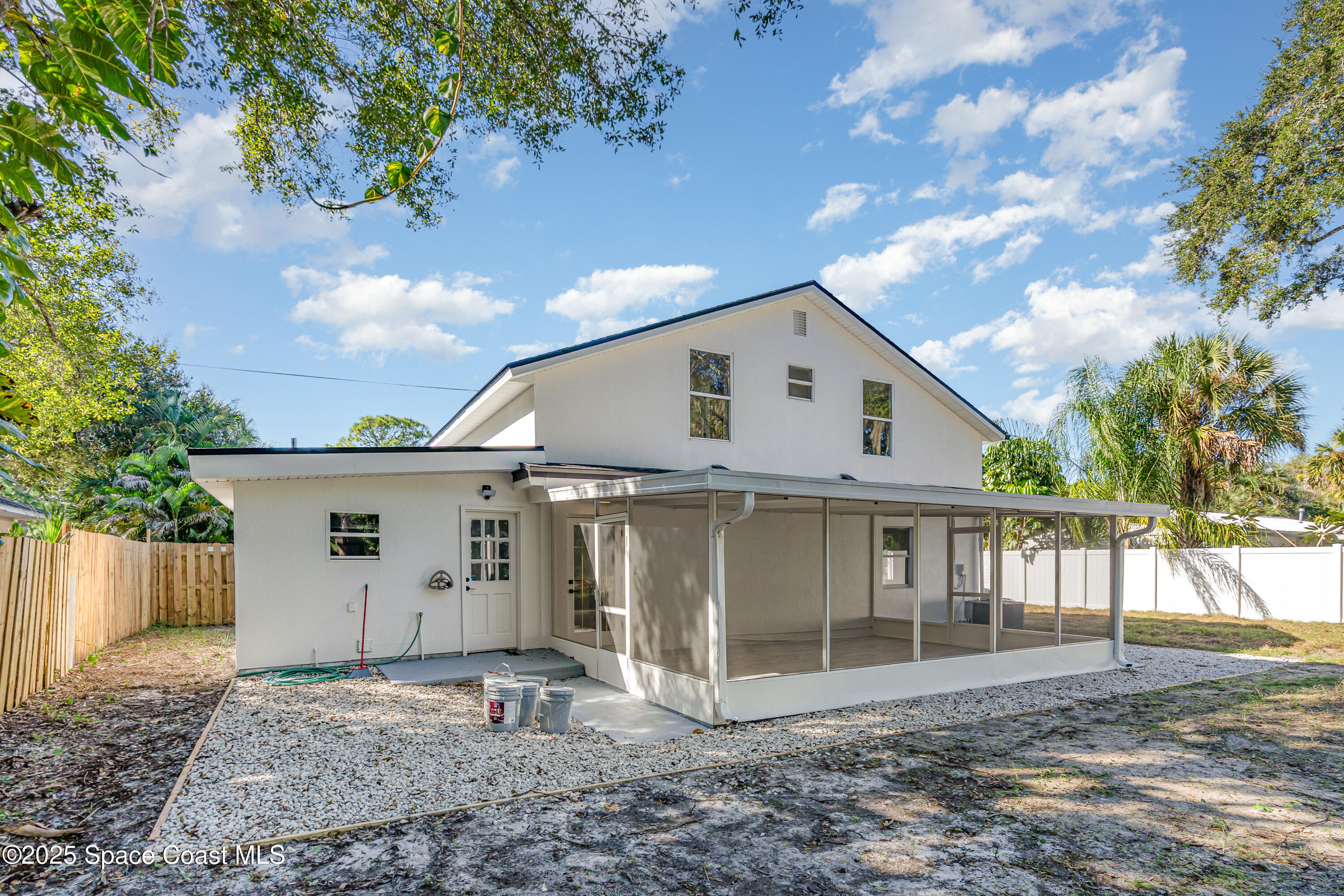 1735 Marywood Road Melbourne, FL 32934 - Photo 23 of 25 a view of a white house next to a yard with wooden fence