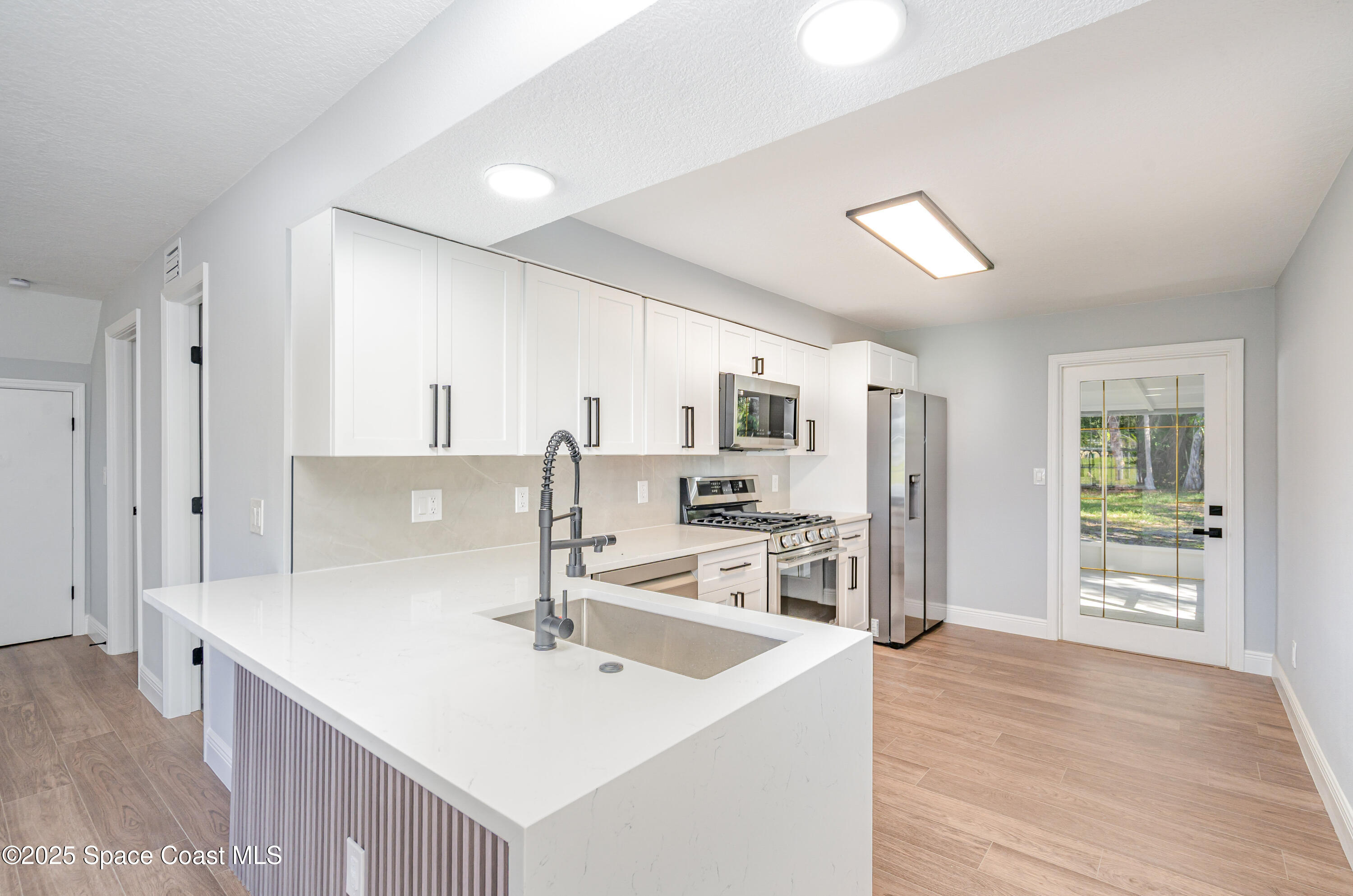 1735 Marywood Road Melbourne, FL 32934 - Photo 8 of 25 a kitchen with stainless steel appliances a sink and a refrigerator