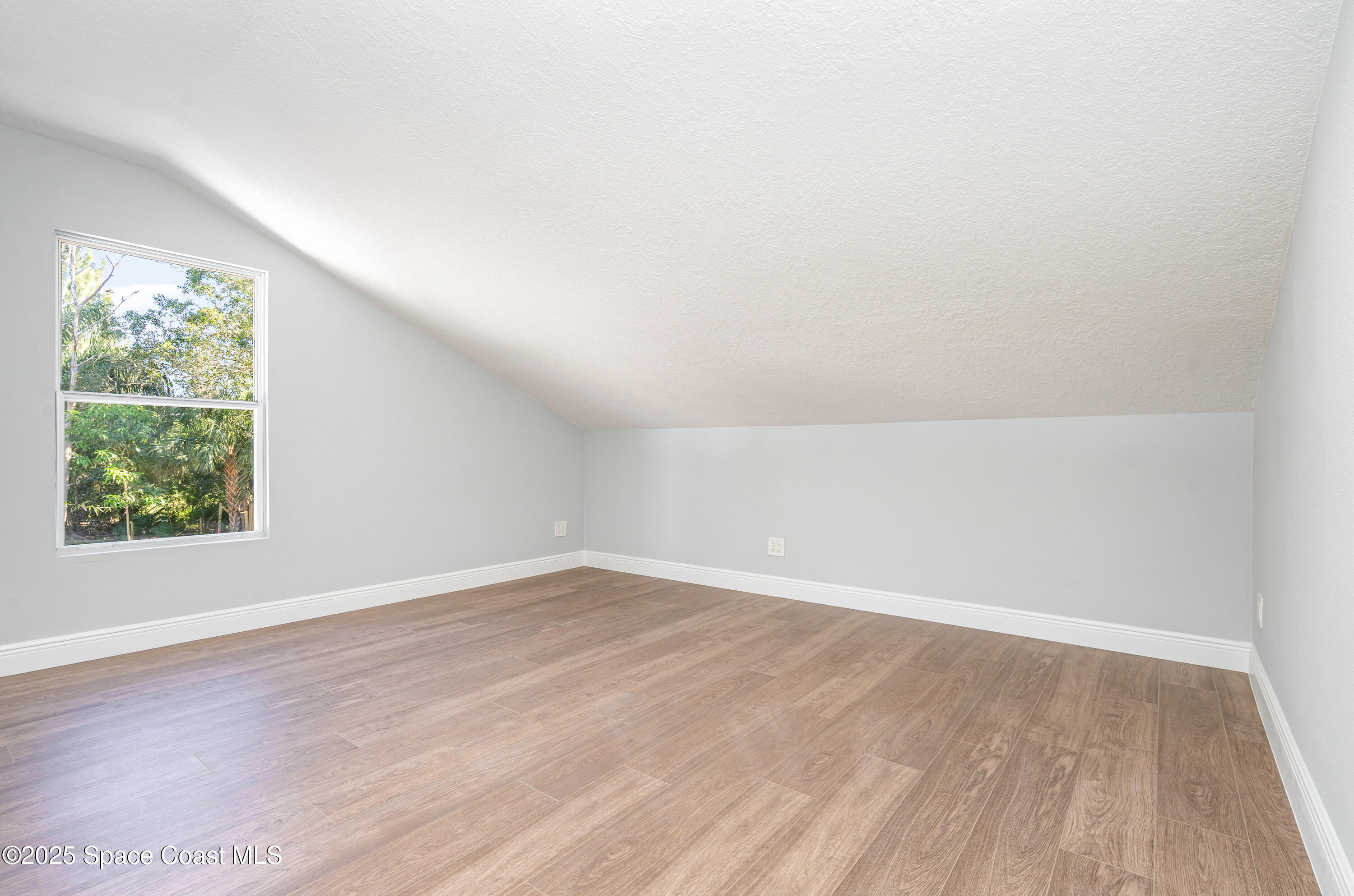 1735 Marywood Road Melbourne, FL 32934 - Photo 10 of 25 an empty room with wooden floor and windows