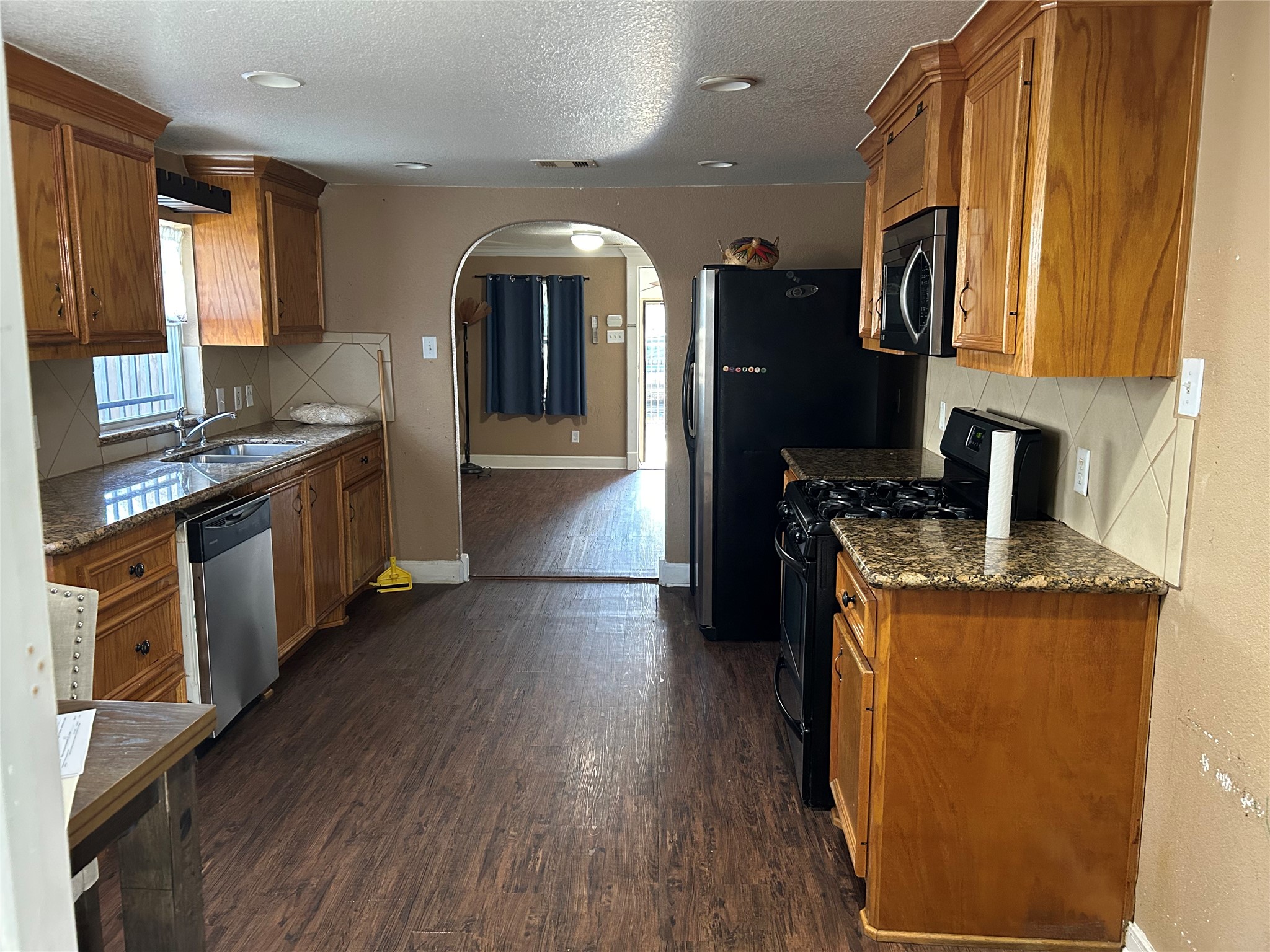 2217 Chew Street Houston, TX 77020 - Photo 8 of 17 a kitchen with stainless steel appliances granite countertop wooden floors and sink