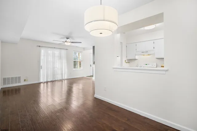 an empty room with wooden floor and mirror